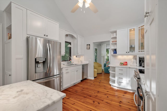 kitchen with light hardwood / wood-style floors, decorative backsplash, sink, stainless steel appliances, and white cabinetry