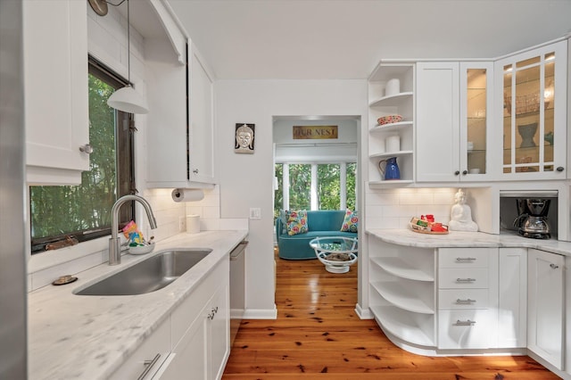 kitchen with backsplash, white cabinets, sink, and a wealth of natural light