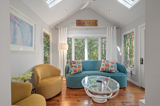 interior space with a skylight, hardwood / wood-style flooring, and high vaulted ceiling