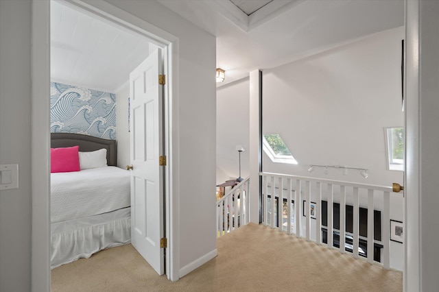 hall with light colored carpet and a skylight