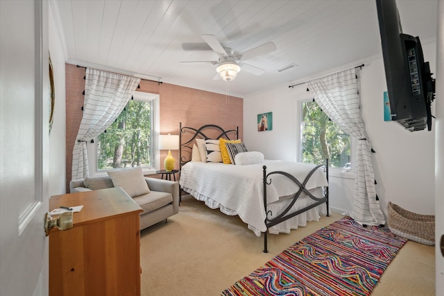 bedroom with carpet floors, ornamental molding, multiple windows, and ceiling fan