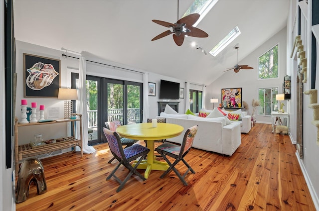 dining room featuring a skylight, light wood-type flooring, and plenty of natural light