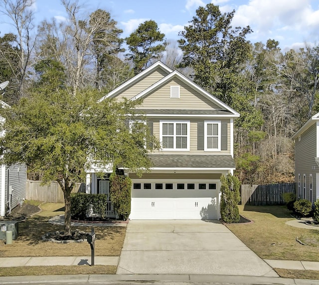 traditional-style home with a shingled roof, concrete driveway, fence, and an attached garage