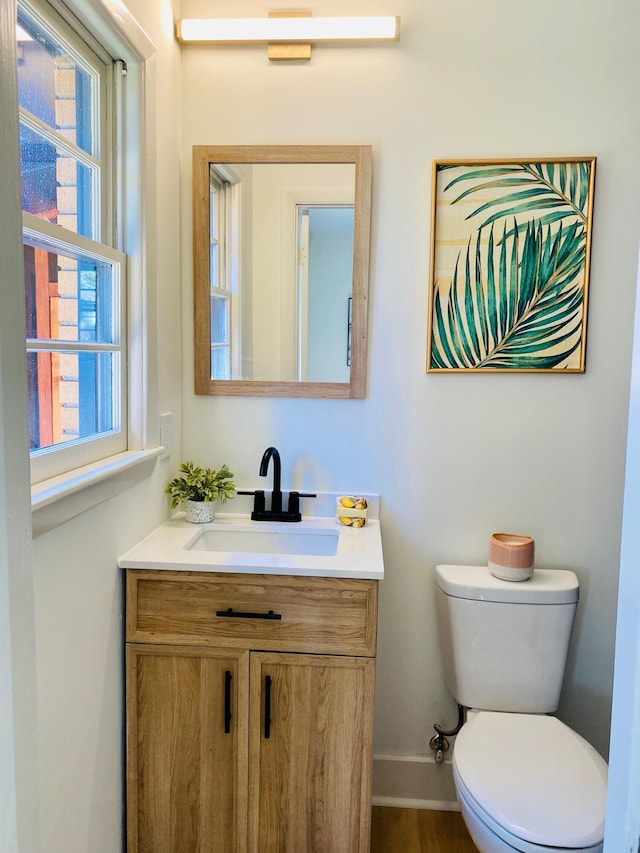 bathroom featuring vanity, toilet, and a wealth of natural light