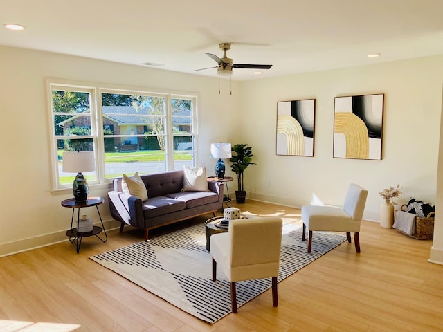 living room featuring ceiling fan, plenty of natural light, and light hardwood / wood-style floors