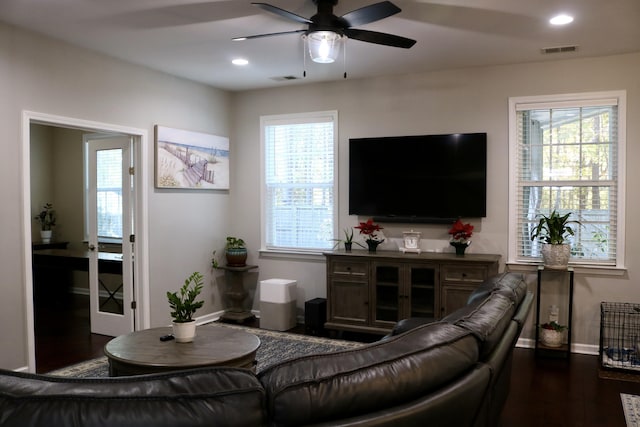 living room featuring ceiling fan and dark wood-type flooring