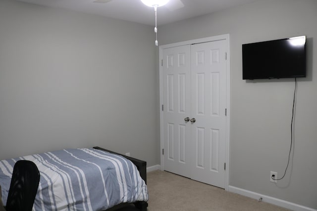 bedroom featuring a closet, light carpet, and ceiling fan