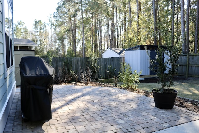 view of patio / terrace with area for grilling and a storage unit