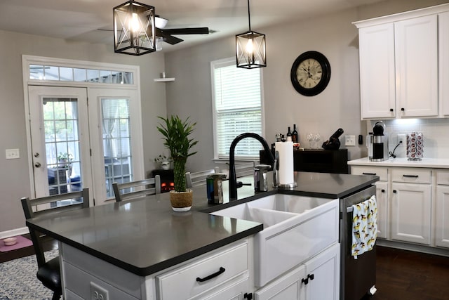 kitchen featuring pendant lighting, white cabinetry, and a center island with sink