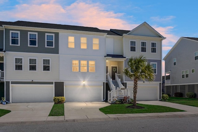 view of property featuring driveway, stairway, and an attached garage