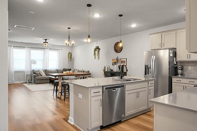 kitchen with light countertops, appliances with stainless steel finishes, a sink, and visible vents