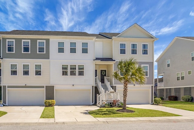 view of front of home featuring a garage, driveway, and stairway