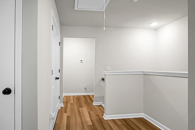 corridor featuring attic access, baseboards, an upstairs landing, and wood finished floors