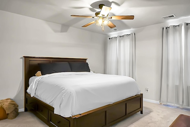 bedroom featuring a ceiling fan, light carpet, visible vents, and baseboards