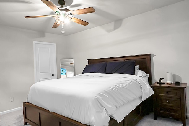 bedroom with a ceiling fan, light carpet, and baseboards