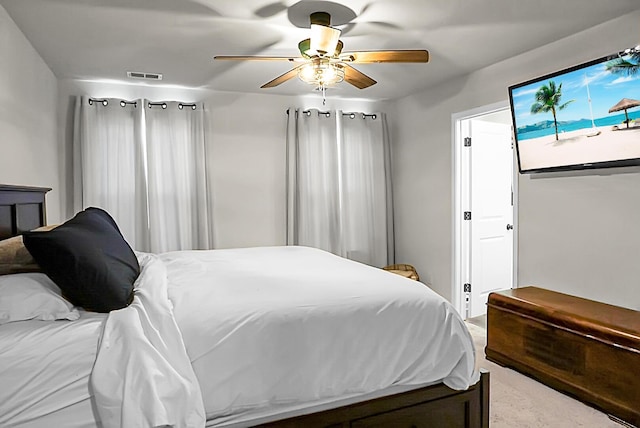 carpeted bedroom featuring a ceiling fan and visible vents