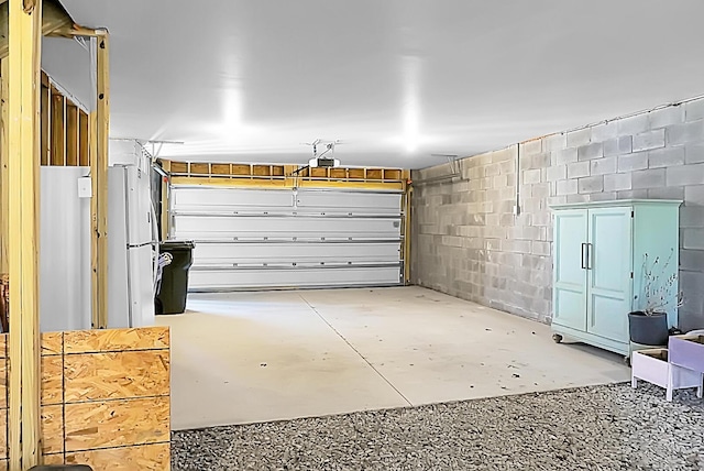 garage with concrete block wall and a garage door opener