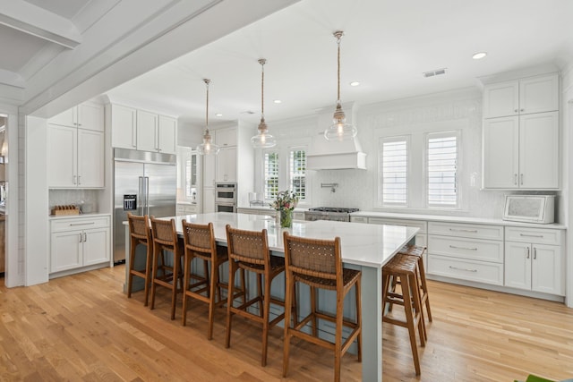 3894 Sawyers Island Dr, Mount Pleasant, SC 29466 - kitchen featuring visible vents, light wood finished floors, a breakfast bar, stainless steel appliances, and white cabinetry