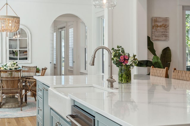 3894 Sawyers Island Dr, Mount Pleasant, SC 29466 - kitchen with light countertops, a chandelier, blue cabinetry, arched walkways, and light wood-style floors