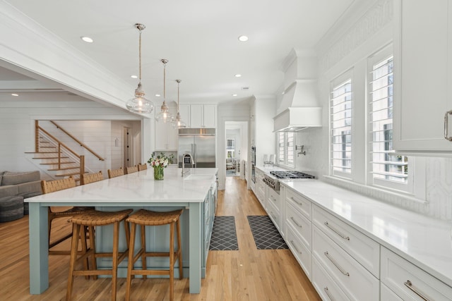 3894 Sawyers Island Dr, Mount Pleasant, SC 29466 - kitchen featuring light wood finished floors, a kitchen breakfast bar, stainless steel appliances, white cabinets, and ornamental molding