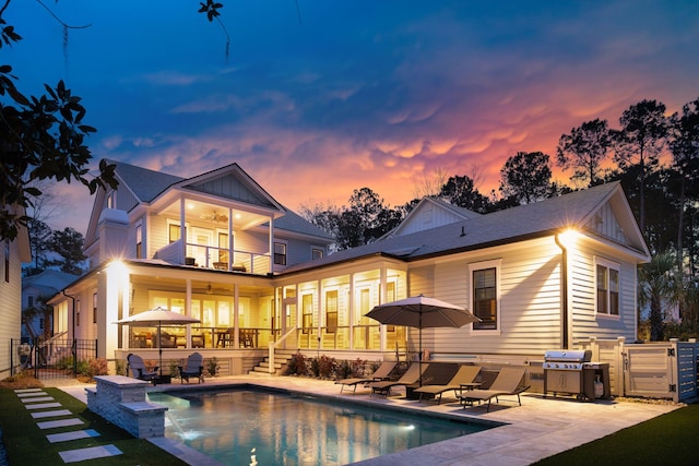 3894 Sawyers Island Dr, Mount Pleasant, SC 29466 - back of house at dusk featuring fence, a patio, board and batten siding, a balcony, and a ceiling fan