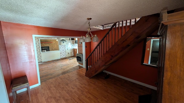 116 Stillfield Dr, Moncks Corner, SC 29461 - staircase featuring wood finished floors, a textured ceiling, heating unit, and a fireplace