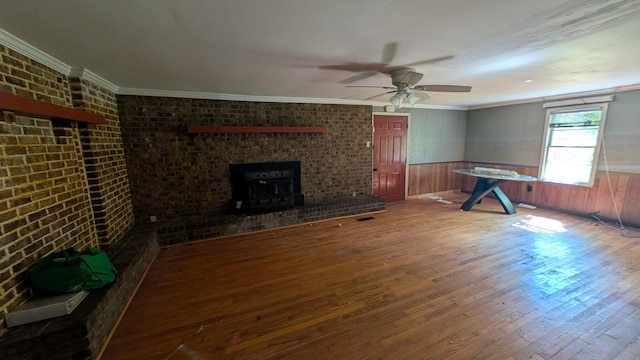 116 Stillfield Dr, Moncks Corner, SC 29461 - unfurnished living room with hardwood / wood-style flooring, a ceiling fan, wainscoting, crown molding, and a wood stove