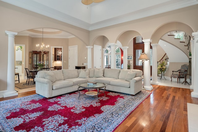 living room with hardwood / wood-style floors, ceiling fan with notable chandelier, and ornamental molding