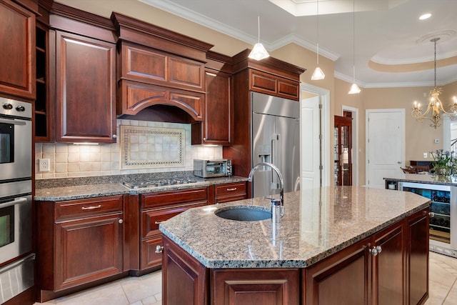 kitchen featuring dark stone counters, a center island with sink, sink, wine cooler, and stainless steel appliances