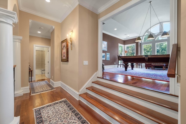 hallway with decorative columns, hardwood / wood-style floors, and ornamental molding