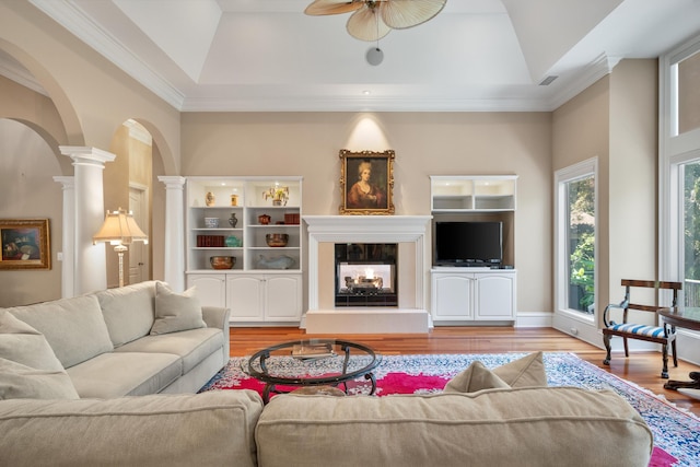 living room featuring ceiling fan, light hardwood / wood-style floors, a raised ceiling, and ornamental molding