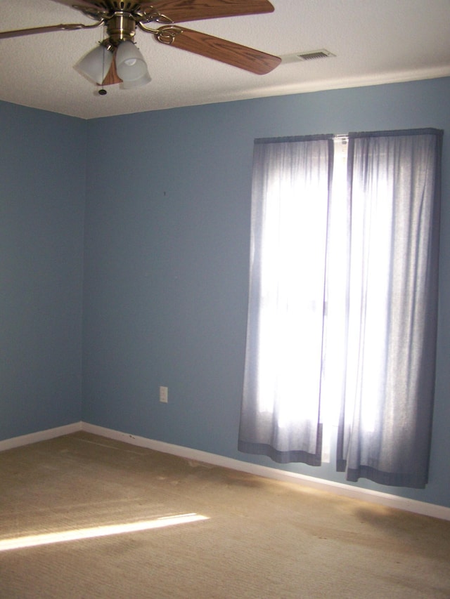 carpeted empty room featuring ceiling fan