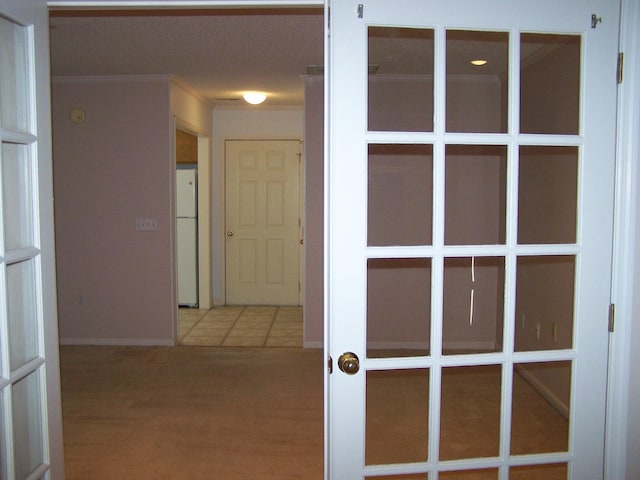 hallway featuring french doors, crown molding, and hardwood / wood-style flooring