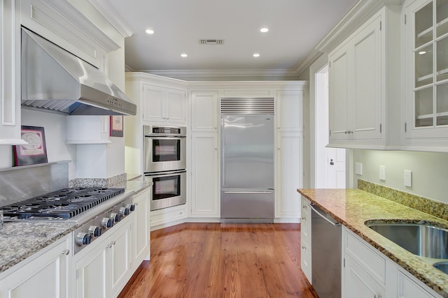 1 Vendue Range Range Unit I, Charleston, SC 29401 - kitchen with appliances with stainless steel finishes, under cabinet range hood, white cabinets, light wood-type flooring, and recessed lighting