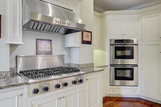 1 Vendue Range Range Unit I, Charleston, SC 29401 - kitchen featuring under cabinet range hood, appliances with stainless steel finishes, dark wood-style floors, and light stone counters
