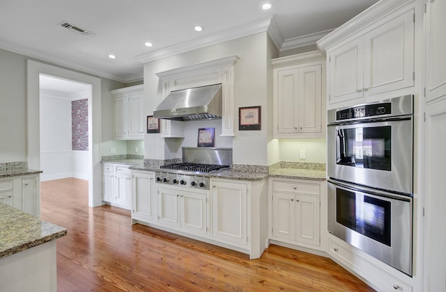 1 Vendue Range Range Unit I, Charleston, SC 29401 - kitchen featuring stainless steel appliances, under cabinet range hood, light wood finished floors, ornamental molding, and white cabinetry