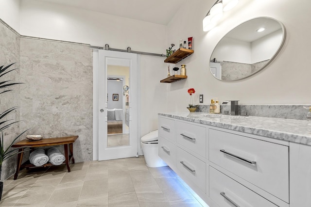 bathroom featuring tile patterned floors, toilet, vanity, and tile walls