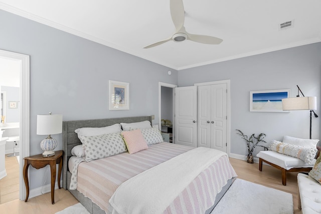 bedroom featuring baseboards, a closet, light wood-style flooring, crown molding, and visible vents