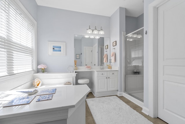 bathroom with tile patterned flooring, a shower stall, and vanity