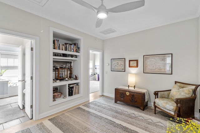 sitting room featuring visible vents, a ceiling fan, crown molding, attic access, and wood finished floors
