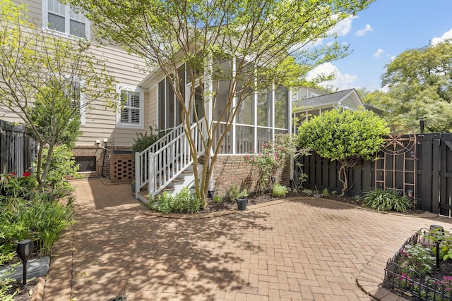 view of patio featuring a sunroom and fence