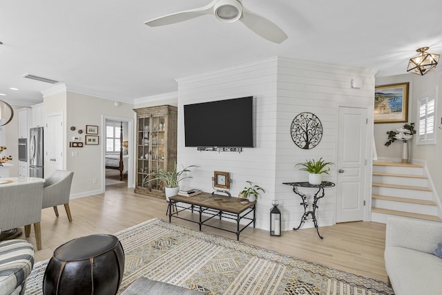 living area featuring light wood-type flooring, a ceiling fan, visible vents, stairway, and baseboards