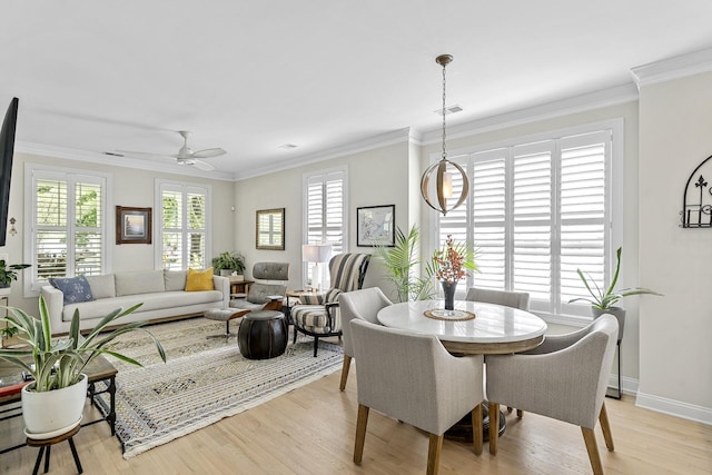 dining area with ceiling fan, light wood-type flooring, ornamental molding, visible vents, and baseboards