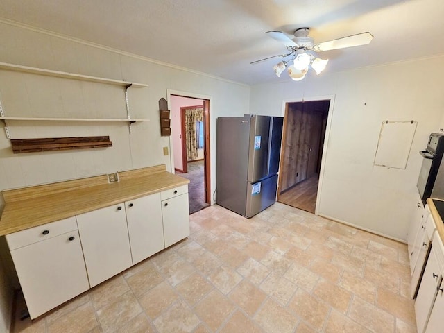 kitchen with a ceiling fan, freestanding refrigerator, light countertops, white cabinetry, and open shelves