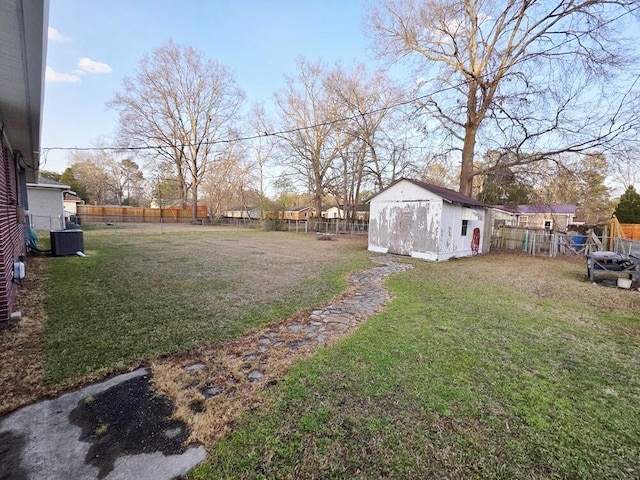 view of yard with an outbuilding, a fenced backyard, and a storage unit