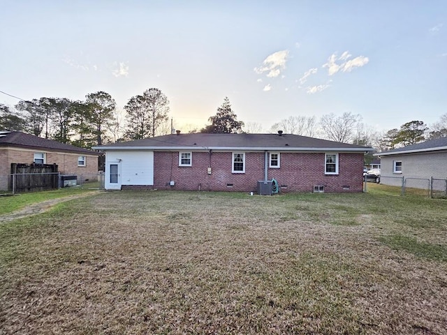 rear view of house with crawl space, brick siding, a yard, and central air condition unit