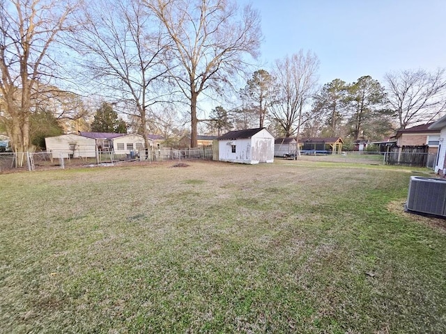 view of yard featuring an outbuilding, central air condition unit, a fenced backyard, and a shed