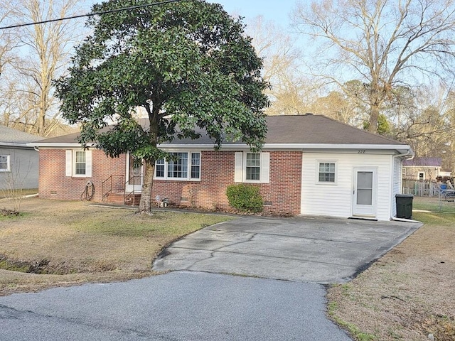 single story home featuring aphalt driveway, brick siding, a shingled roof, crawl space, and a front yard