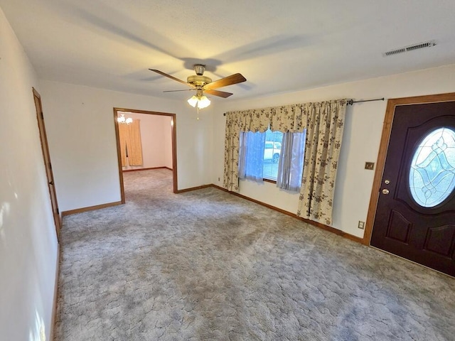 carpeted foyer with a ceiling fan, visible vents, and baseboards