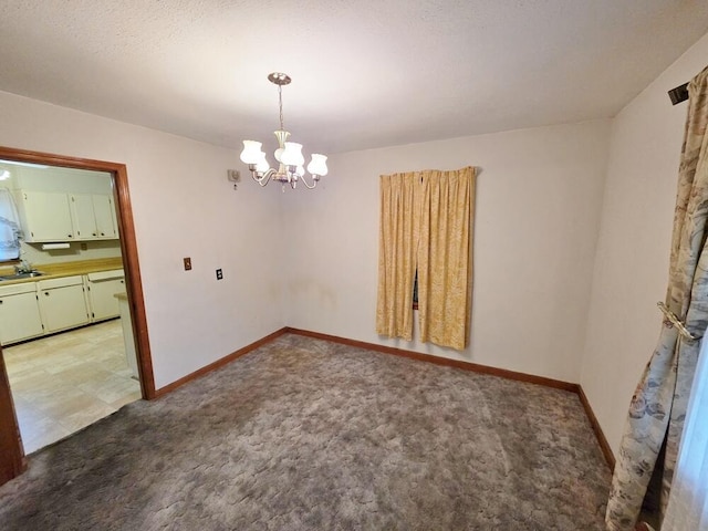 unfurnished dining area with a chandelier, baseboards, a sink, and light colored carpet